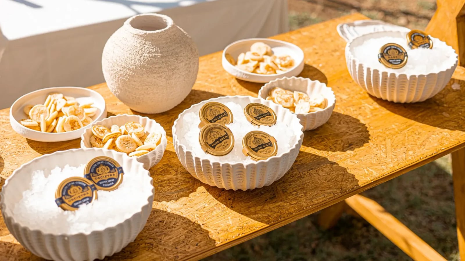 Estación de caviar con blinis sobre mesa de madera
