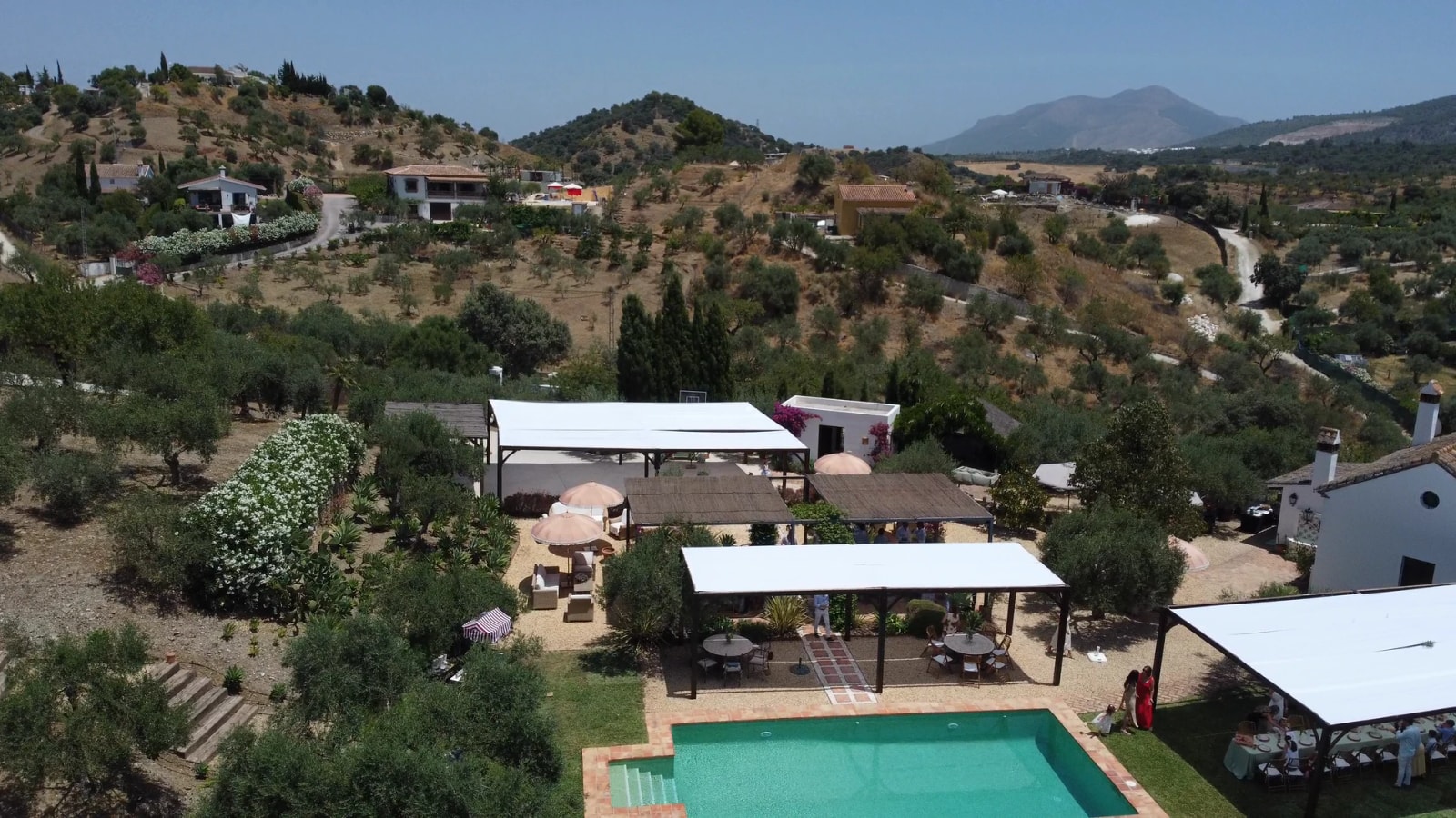 Aerial view of Finca Esencia de Rosa in Monda, with the pool, pergolas and olive grove surrounded by the mountains