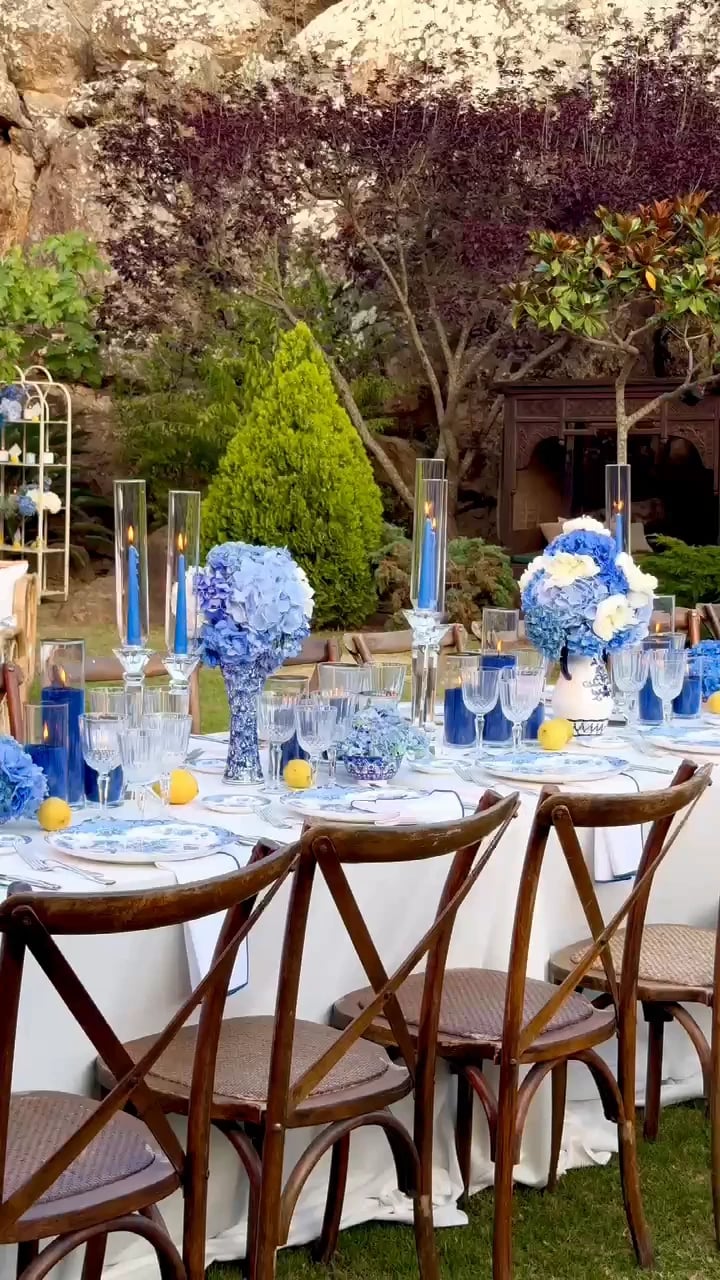 Recorrido por el montaje de una boda en Love Garden, con mesas en azul y blanco entre las rocas y los árboles del jardín