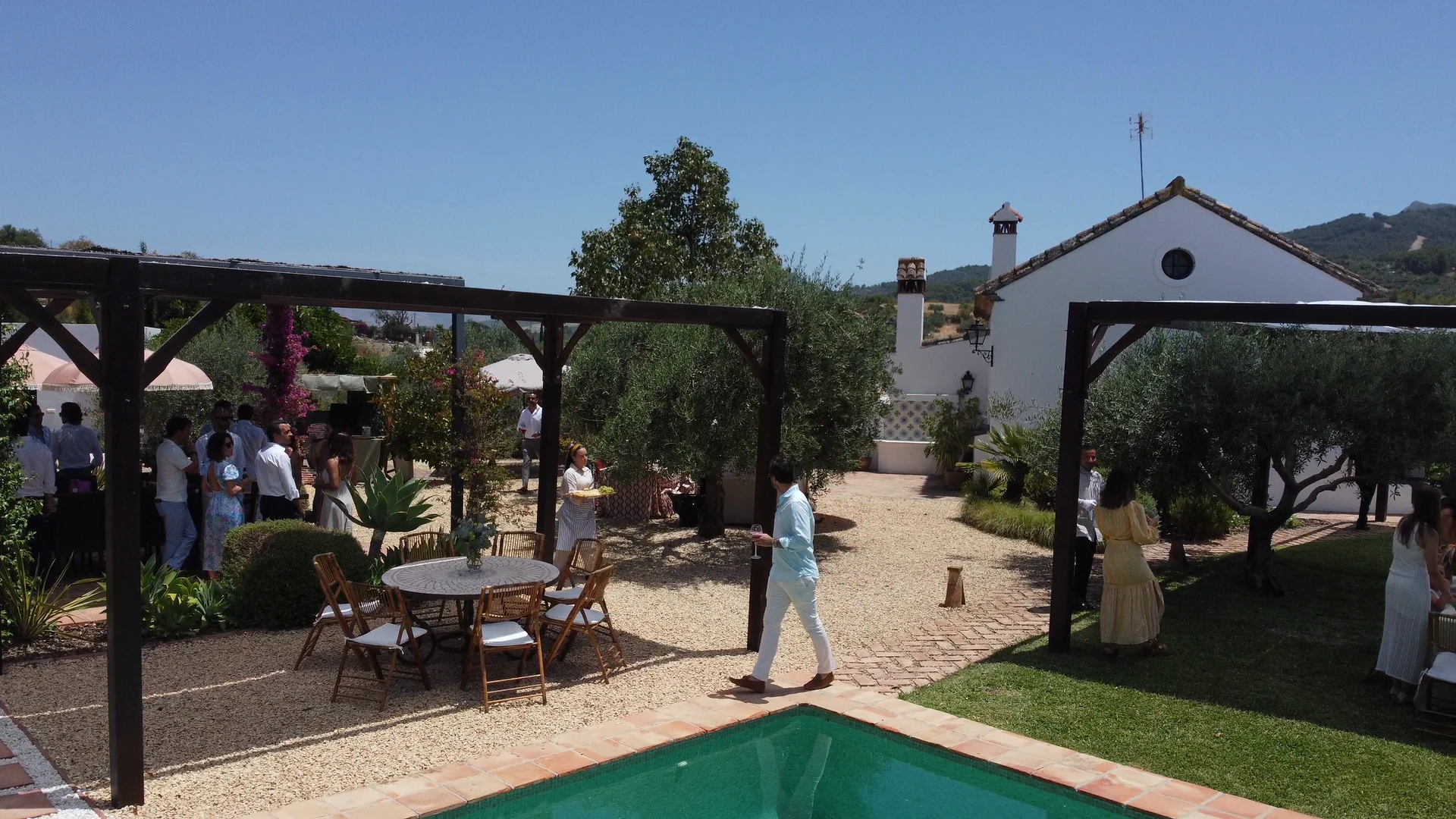 Cóctel de bienvenida en la Finca Esencia de Rosa: invitados y servicio entre las pérgolas, junto a la piscina y los olivos